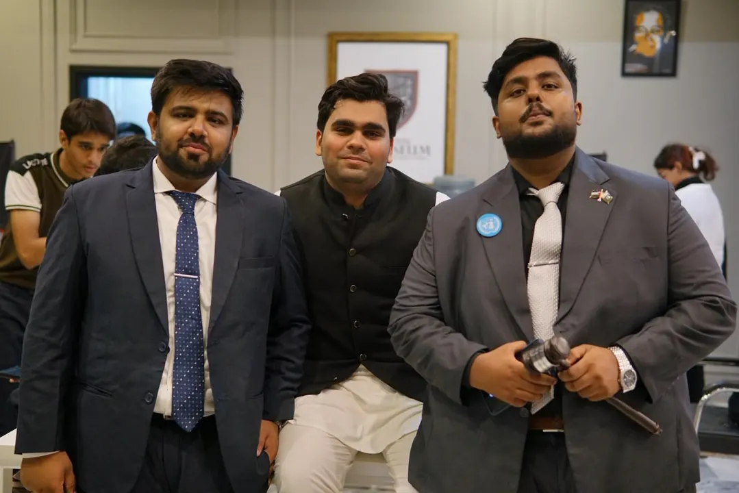 Three ELARA MUN I team members, one holding a gavel