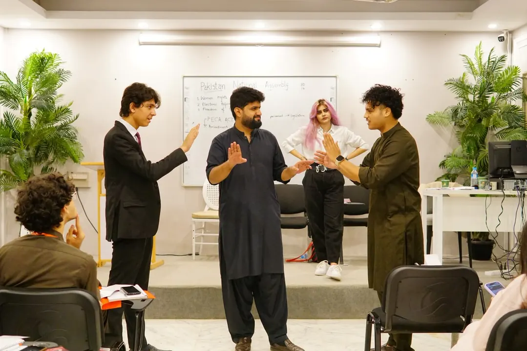 Delegates acting out a scene in the Pakistan National Assembly committee